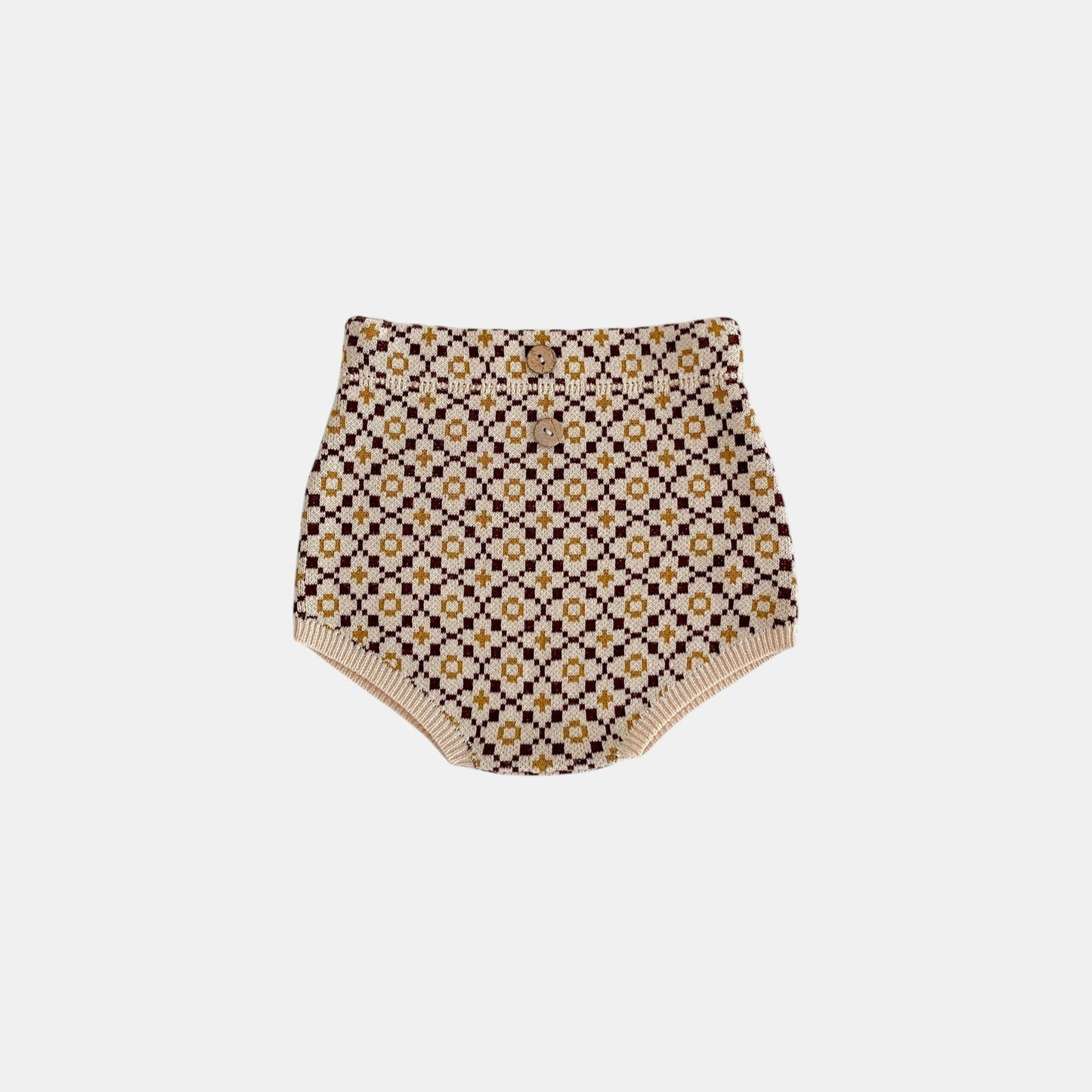 Patterned brown knitted baby bloomers on a white background