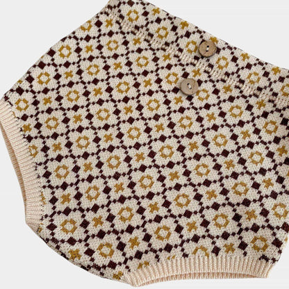 Knitted brown baby bloomers with floral pattern on a white background