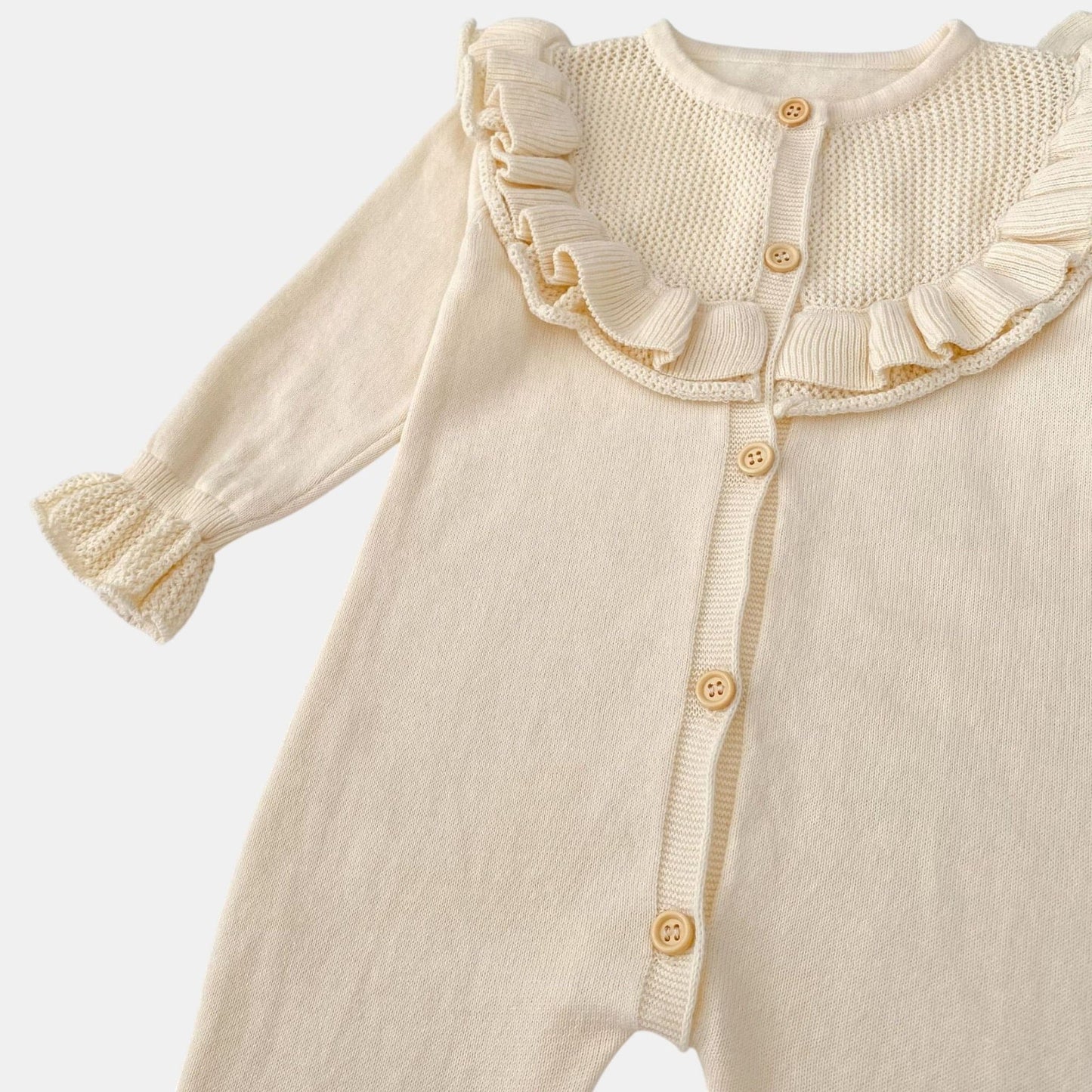 Cream baby romper with ruffled collar on a white background