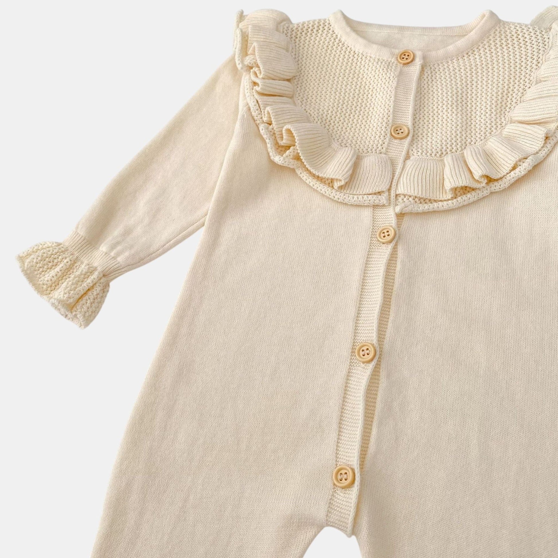 Cream baby romper with ruffled collar on a white background