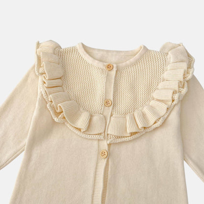 Cream knitted baby romper with ruffled collar on a white background