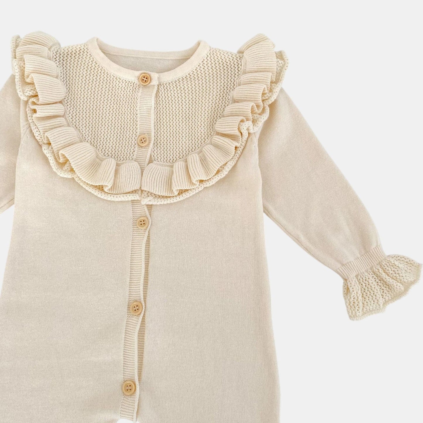 Cream knitted romper with ruffled collar on a white background