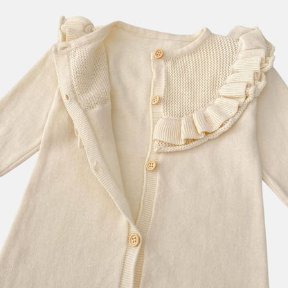 Cream baby romper with ruffled shoulders on a light grey background