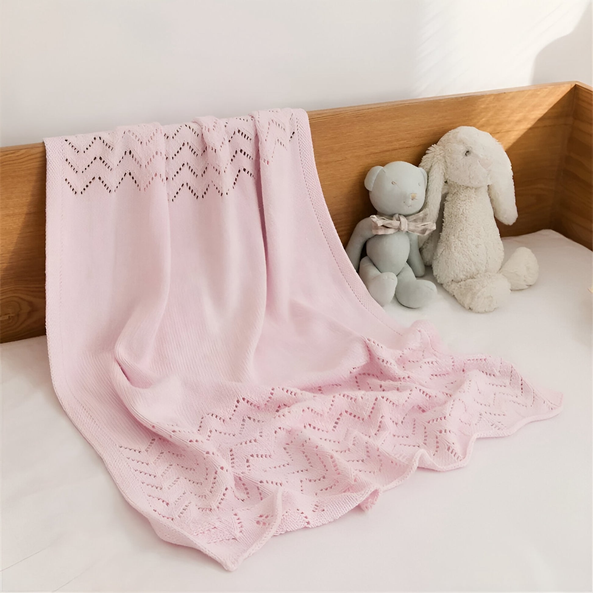 OEKO-TEX® Pink Chevron Knitted Cotton Blanket - Draped on bed -  Bambisserie