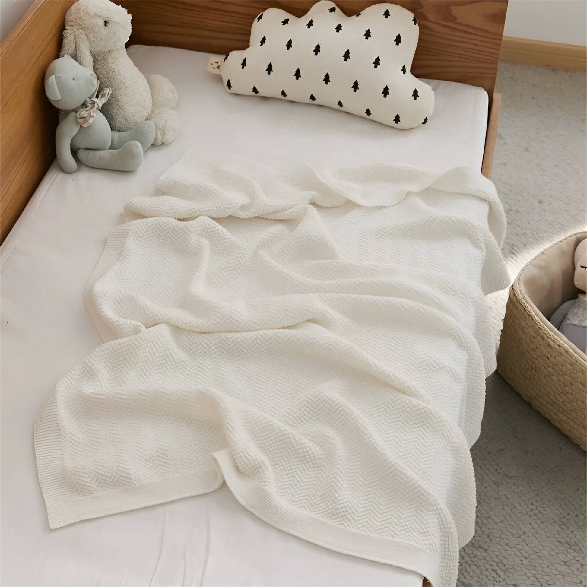 OEKO-TEX® White Waves Knitted Cotton Blanket draped on bed with teddies - Bambisserie
