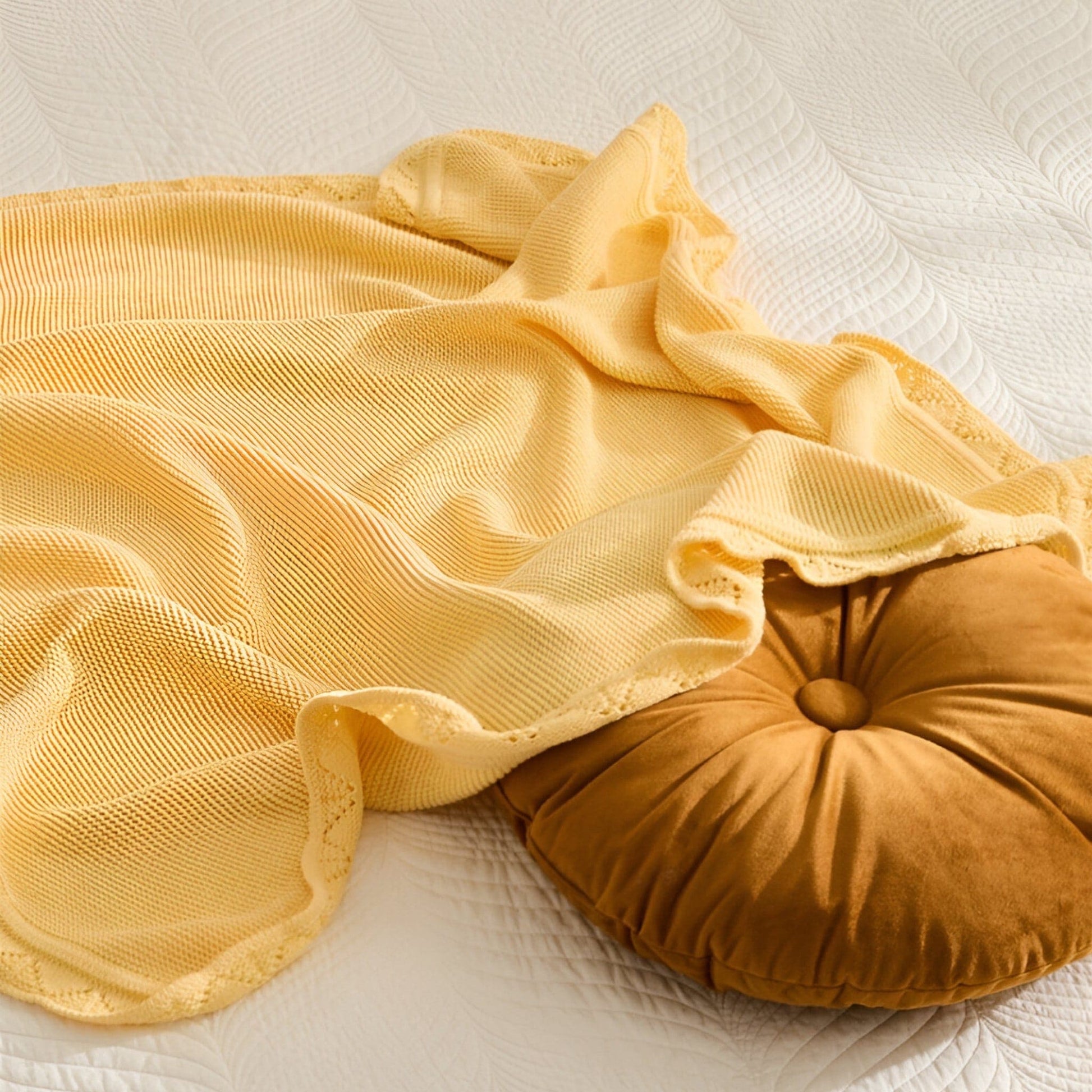 OEKO-TEX® Lullaby Knitted Cotton Blanket, Lemon Yellow - Draped on bed with round pillow - Bambisserie