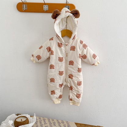 Baby pramsuit with bear pattern hanging on a wooden hanger against a white wall.