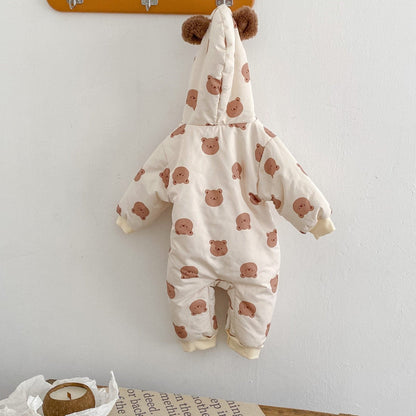 Baby pramsuit with bear pattern hanging on a hook against a white wall.
